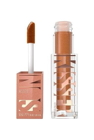 Blush líquido em embalagem transparente com tampa rosé metálica, exibindo o nome “KISS” em letras grandes. Ao lado, o aplicador de esponja aparece retirado do frasco, revelando a cor do produto: um tom quente de terracota cintilante.